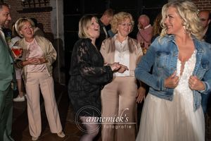 Wedding guests dancing and celebrating during reception in rustic brick venue.