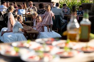 People gathered around tables at an outdoor celebration or party event.