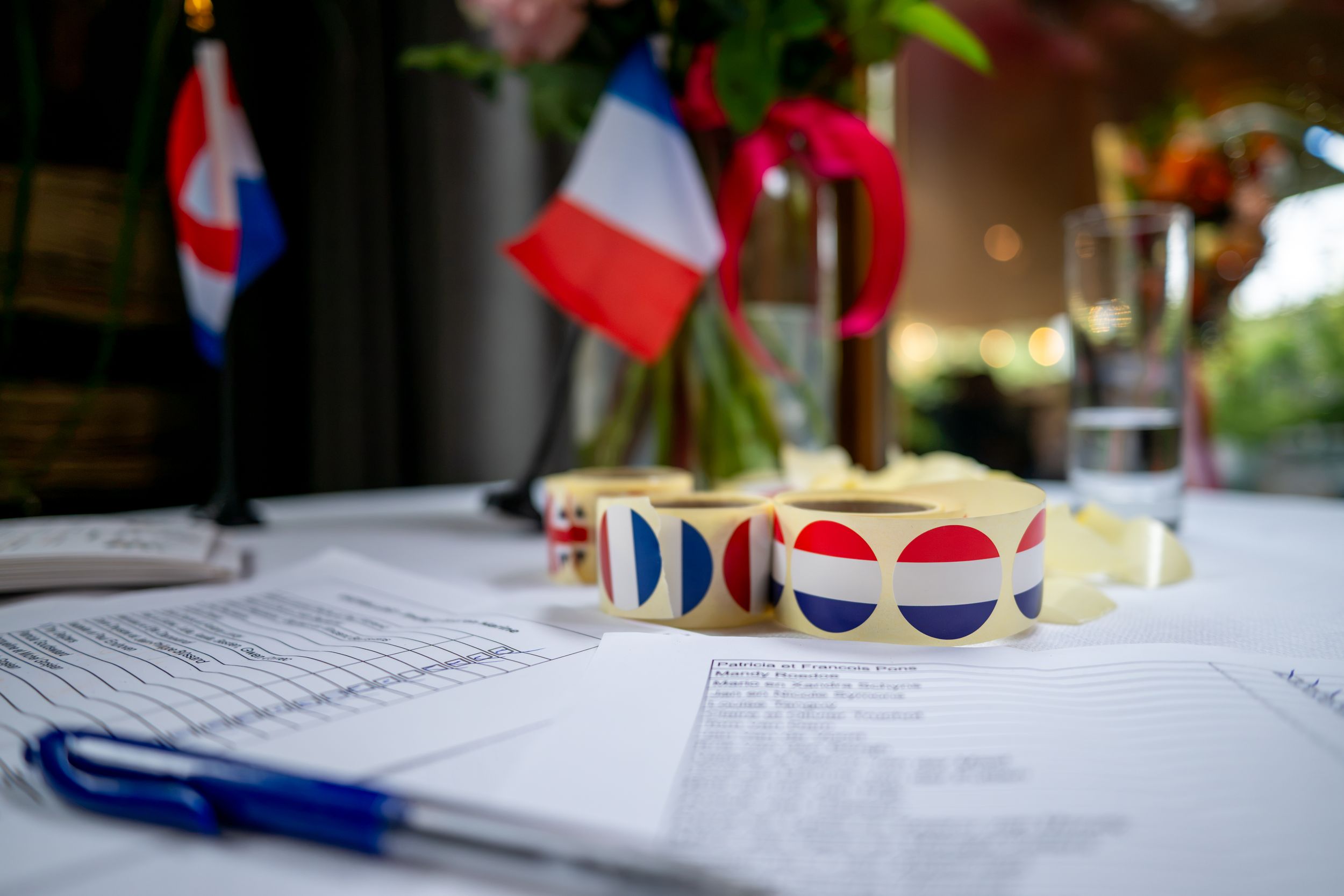 Close-up of French flag decorations and colorful dot stickers on wedding registration papers at a formal ceremony table.