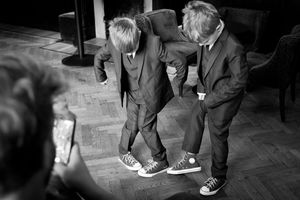 Black and white photograph showing formal footwear and legs at an event.
