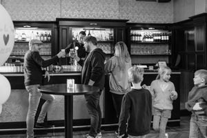 People gathered at a bar counter in black and white photography.
