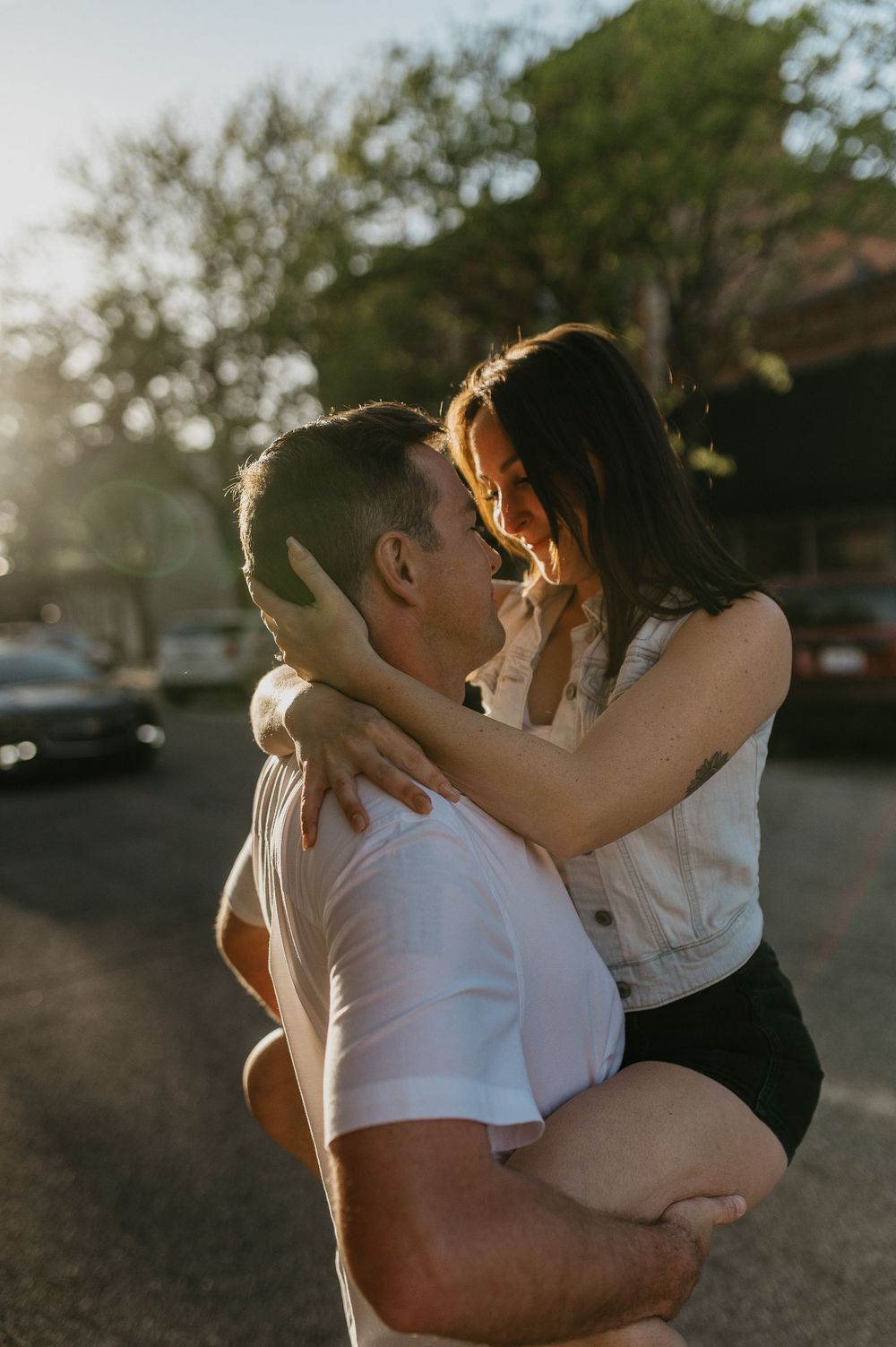 Romantic sunset photo of an intimate embrace in a parking lot.