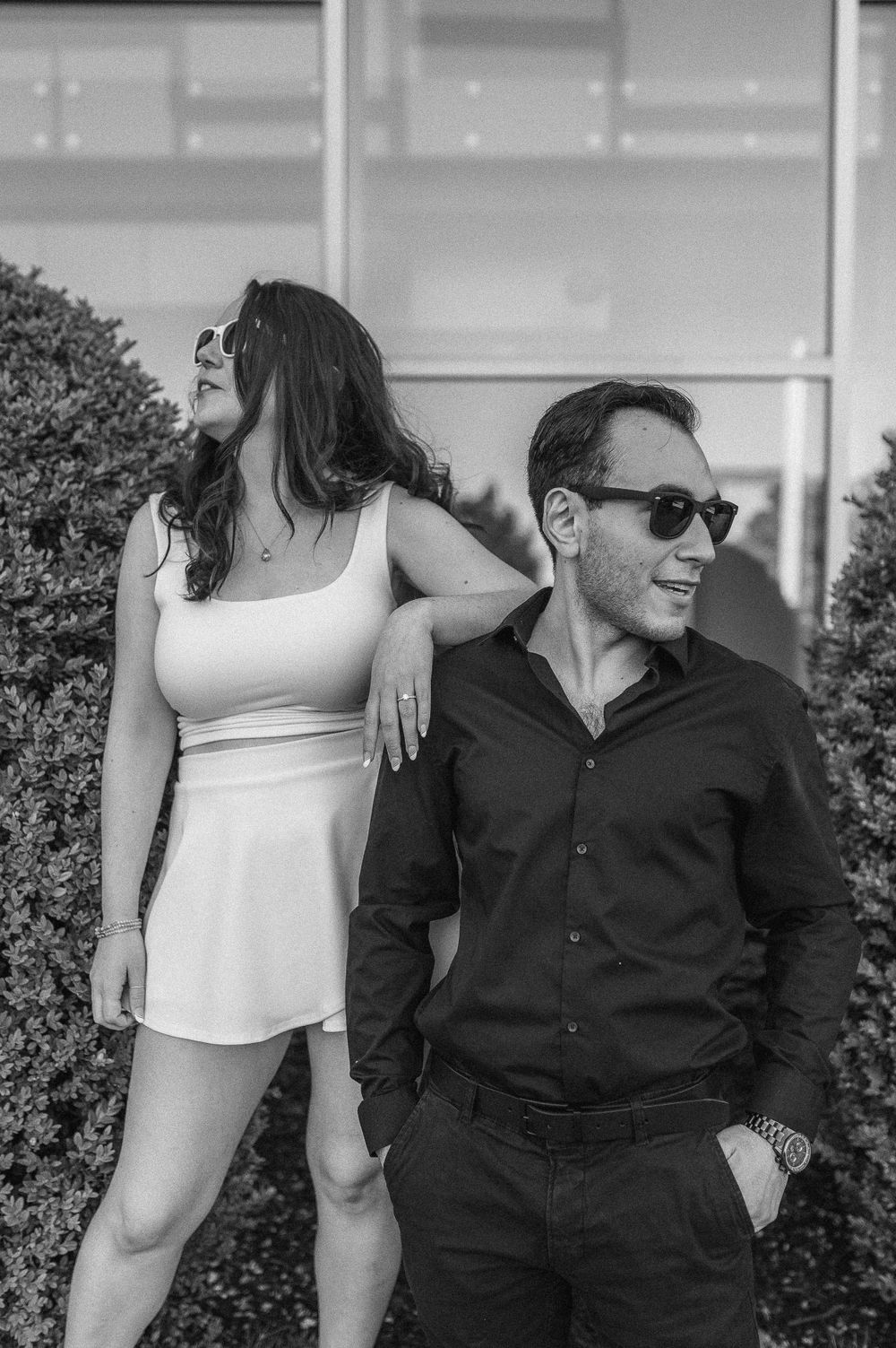 Stylish black and white portrait against garden hedge with casual urban vibe.