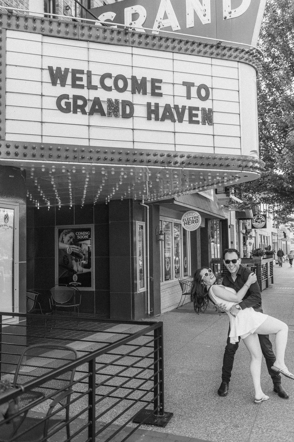 Black and white photo at Grand Haven theater marquee with vintage style pose.