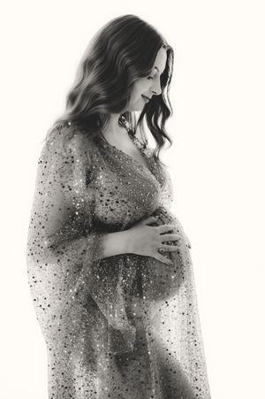 Black and white maternity photos with a sparkly tulle overlay creating an ethereal effect.