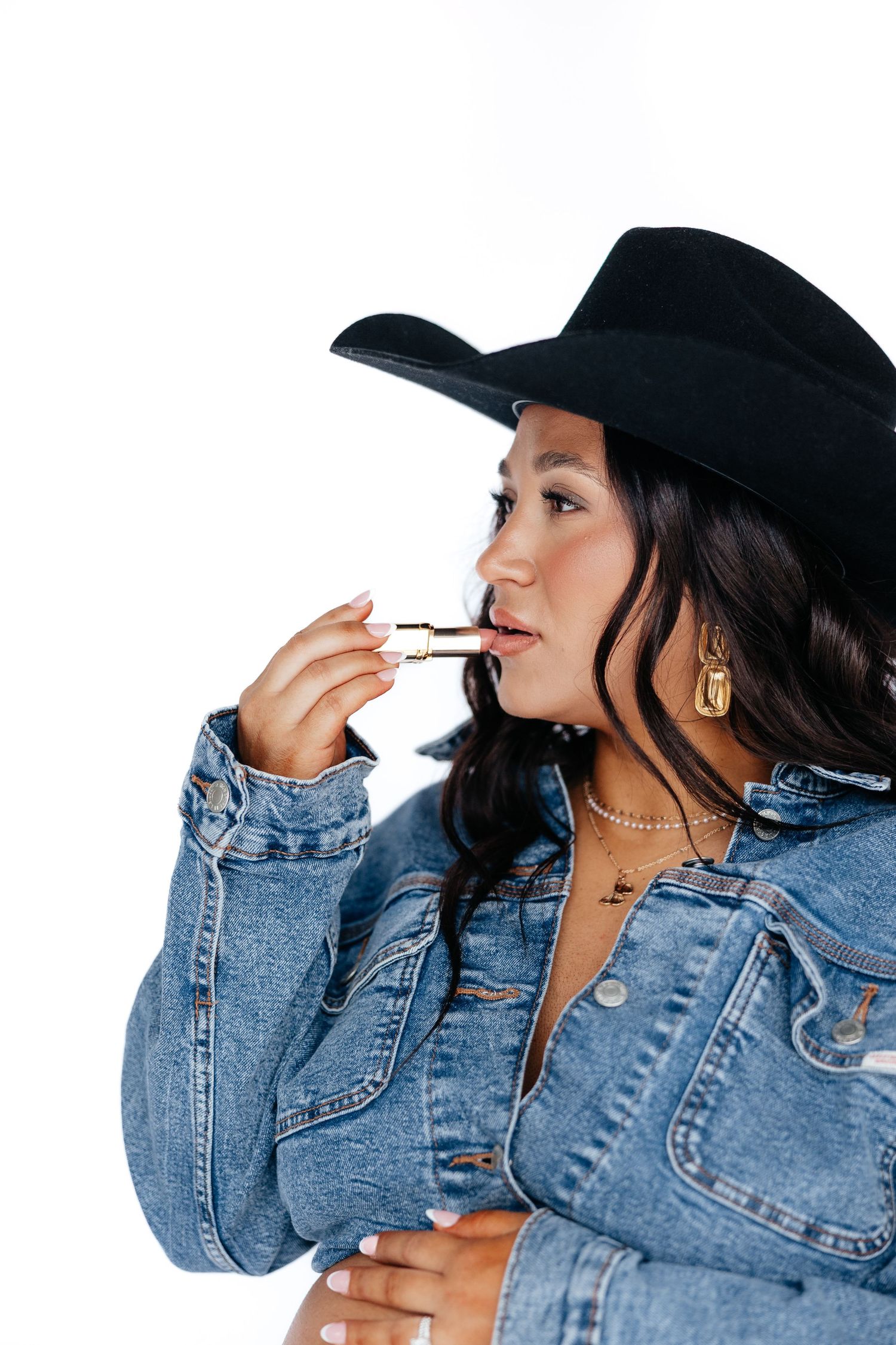 Person in denim jacket and black hat poses in a sequence of profile shots while smoking a cigarette.