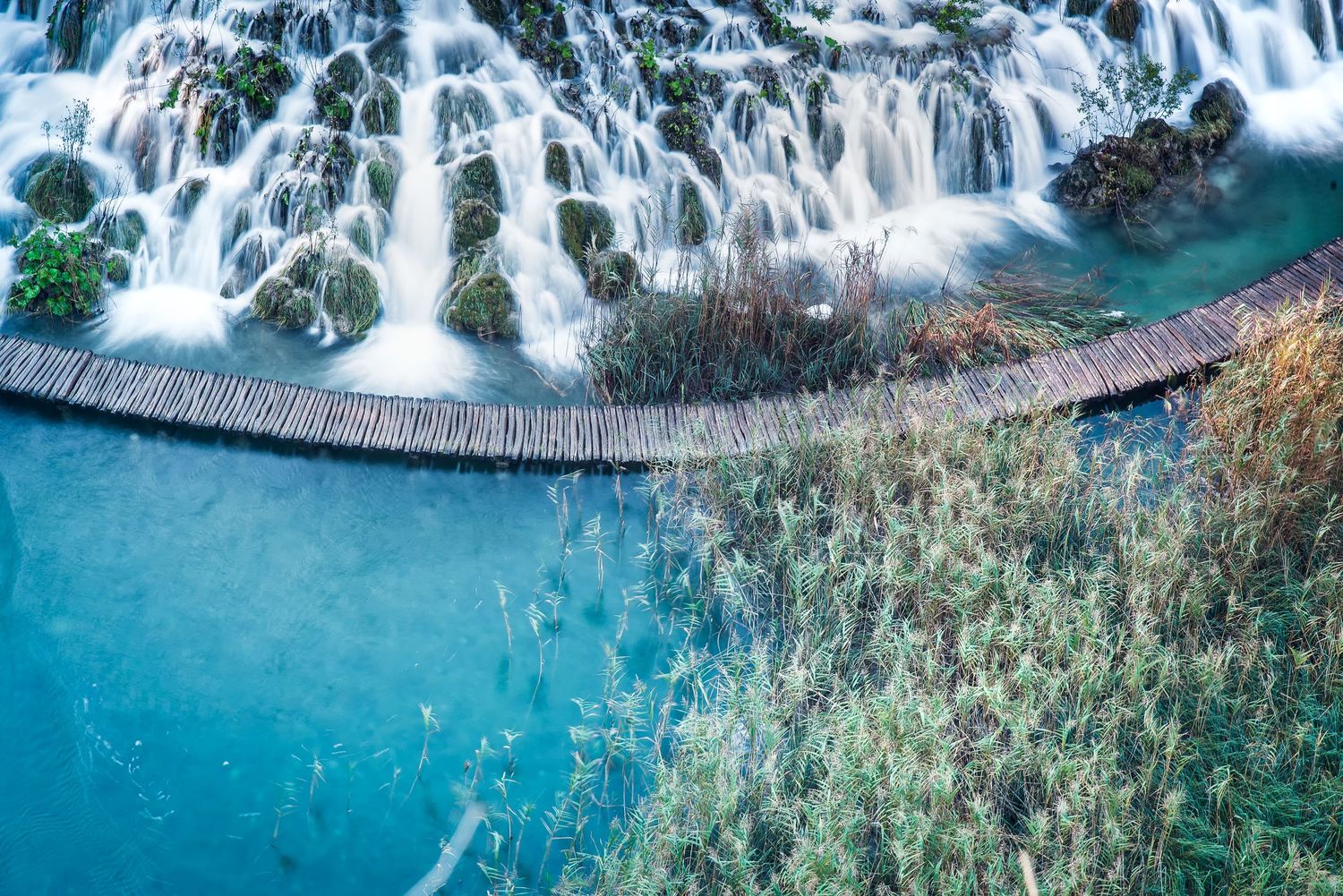 Vista dall'alto di una passerella in legno accanto a una cascata