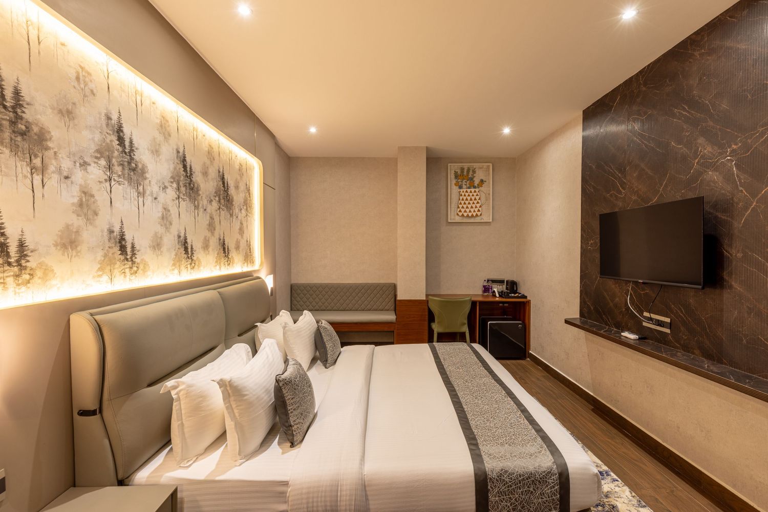 Elegant modern hotel room with king bed, decorative wall art, ambient lighting, and wall-mounted TV.