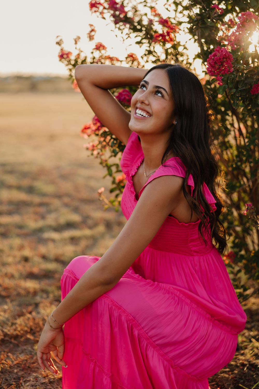 Senior portrait session in Tulia, Texas featuring the color pink and outdoor greenery.