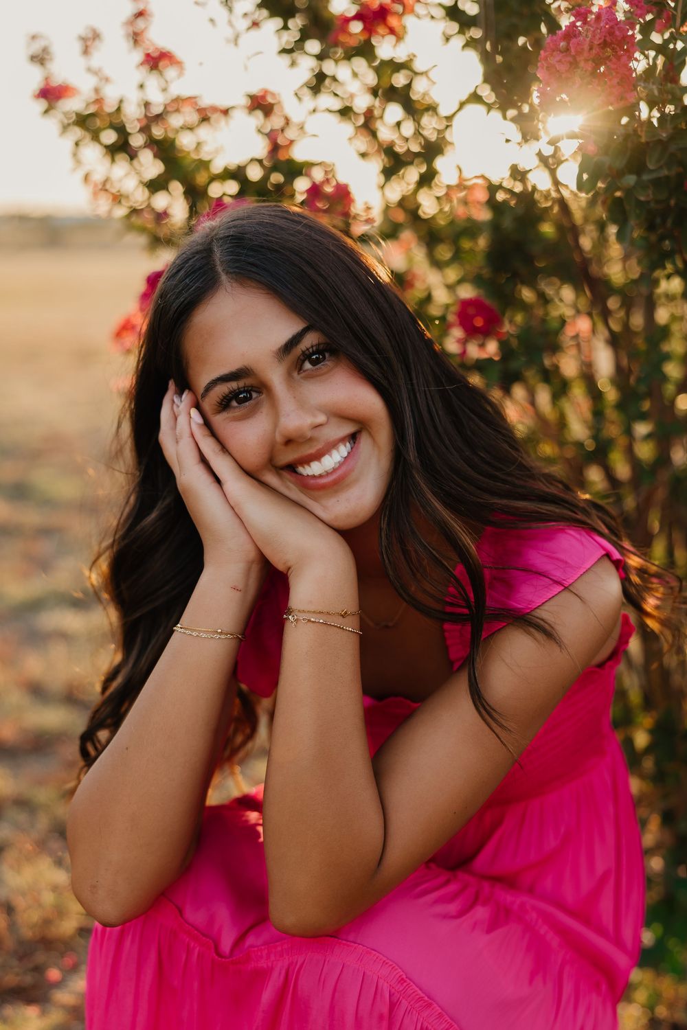 Senior portrait session in Tulia, Texas with pink flowers and pink dress.