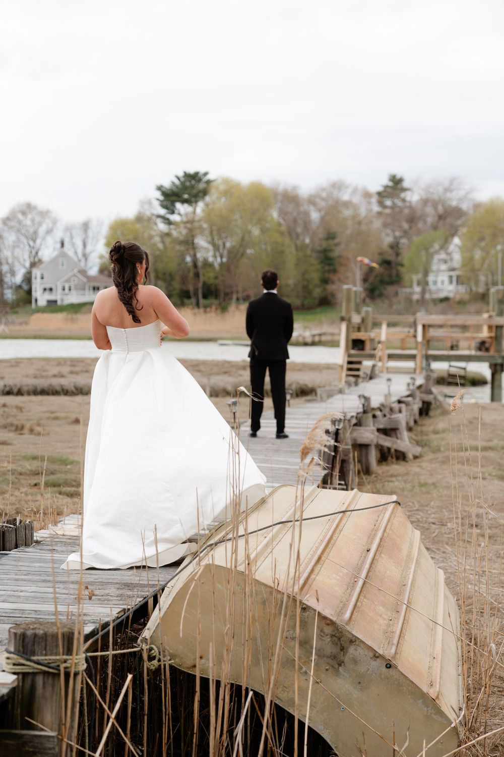 Bride and groom sharing a first look moment on a rustic waterfront dock.