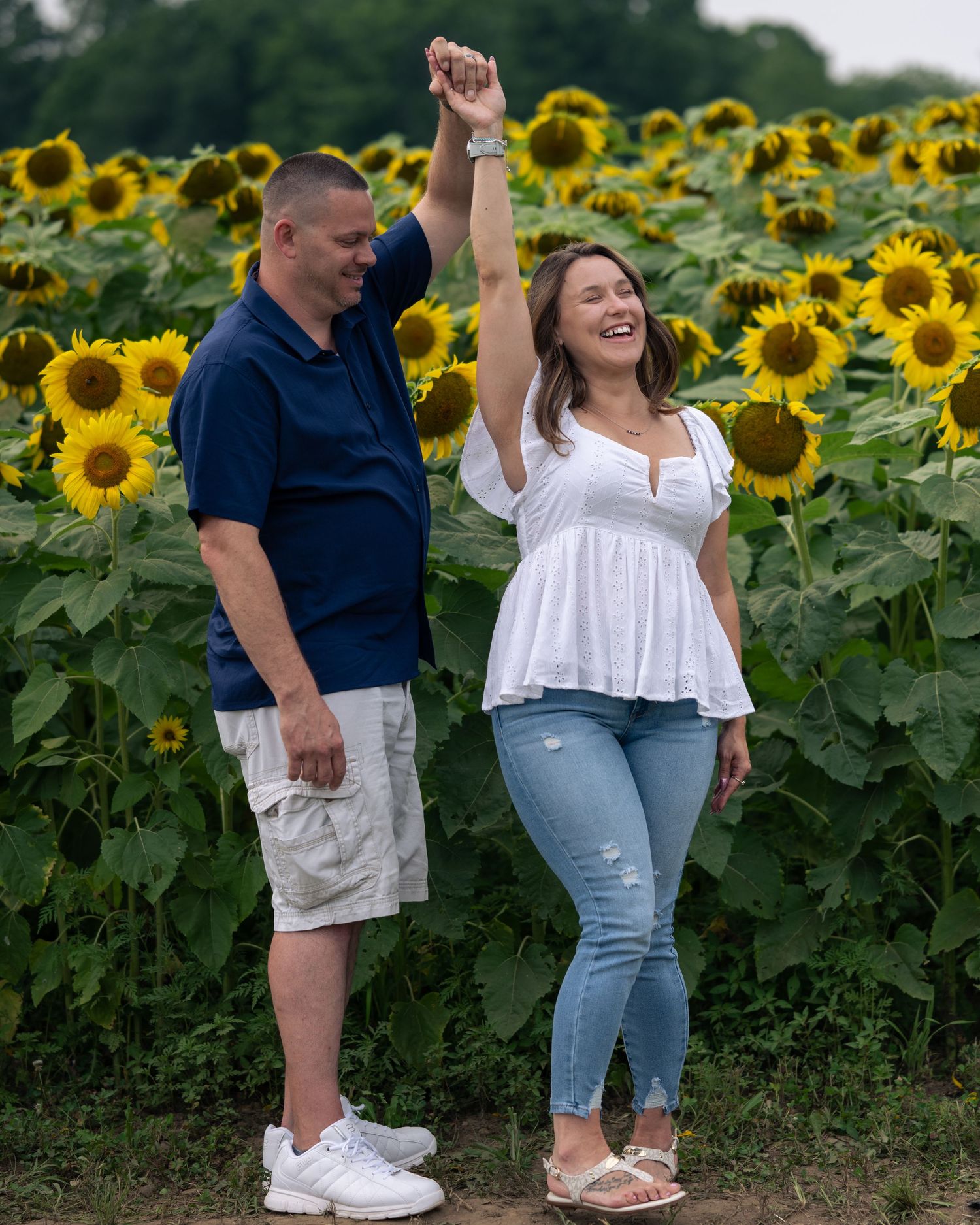 Couple dancing joyfully in a sunflower field, for New Hampshire sunflower mini sessions