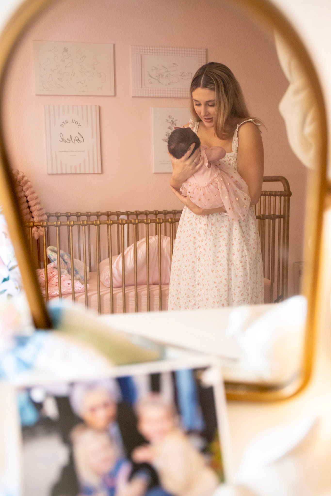 Pregnant woman in jeans and black top with colorful flowers tucked in waistband showcasing baby bump.