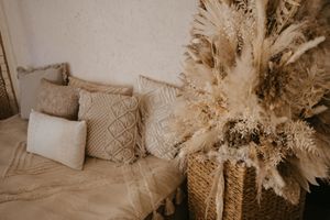 Neutral-toned boho wedding decor features pampas grass, dried flowers, and macrame details in an elegant arrangement.
