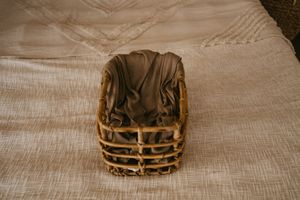 Seven sequential images showing the step-by-step process of wrapping a gift box in brown paper and twine.