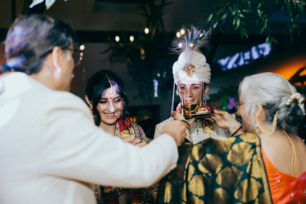 Traditional Indian wedding ceremony with bride and groom in ornate attire, surrounded by family during a sacred ritual.