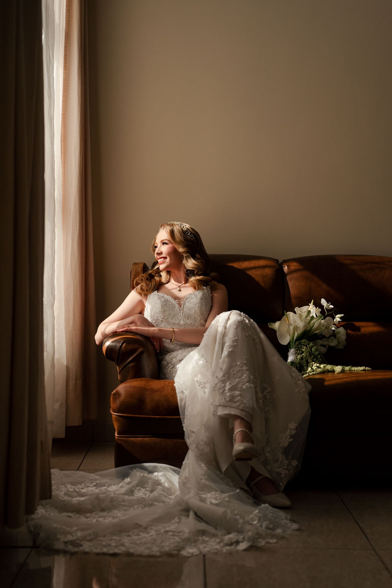 Luxurious wedding portrait with dramatic lighting and hanging crystal decorations on dark background.