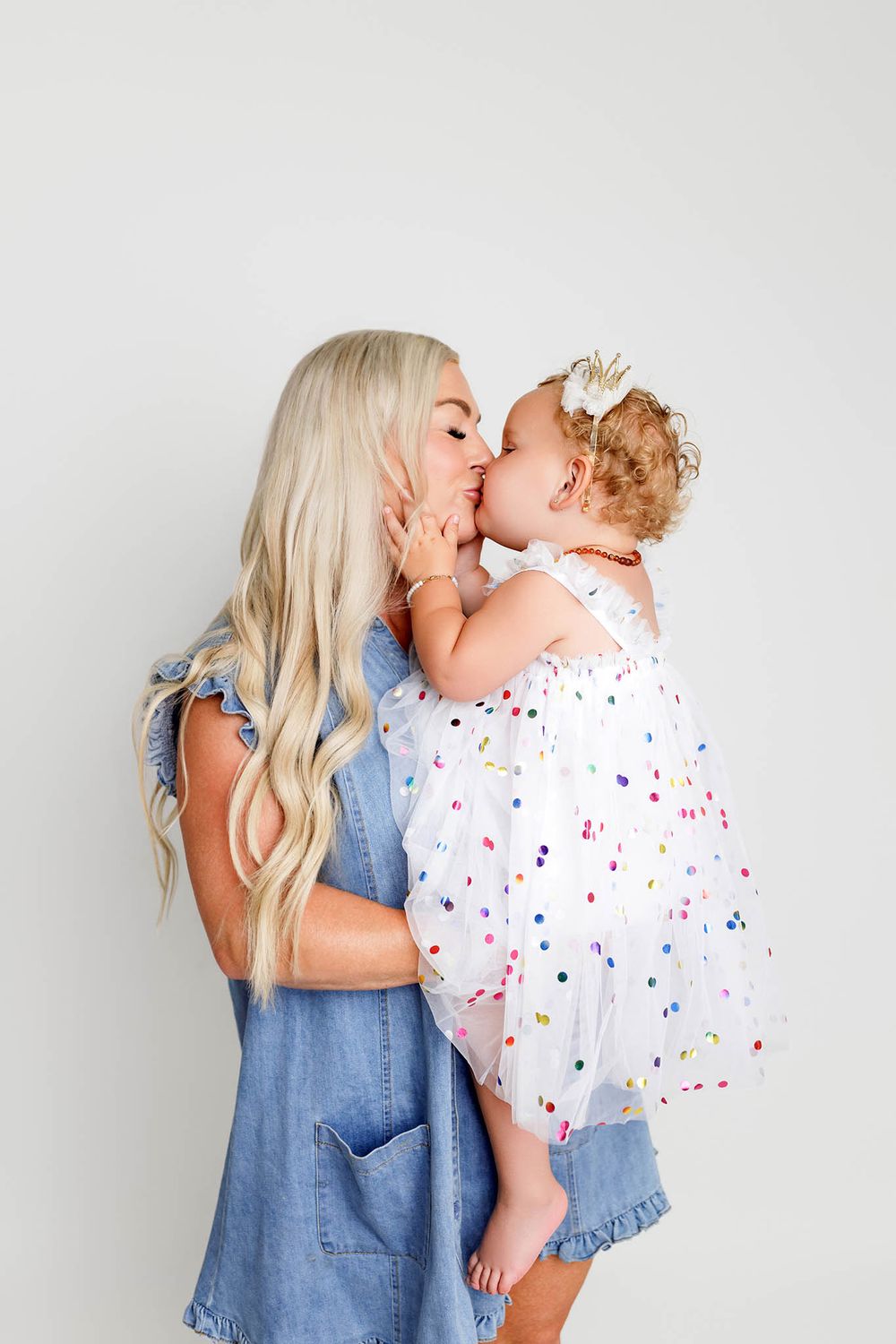 Mom giving kiss to two year old daughter, by affordable Riverside county photographer.