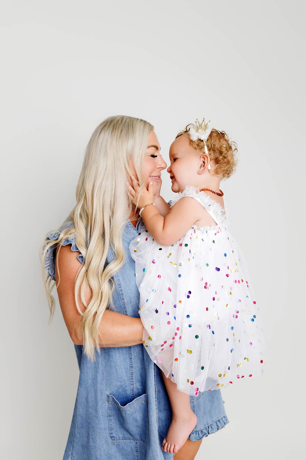 Mom holding two year old daughter, sharing a sweet nose-to-nose moment, by affordable Riverside county photographer.