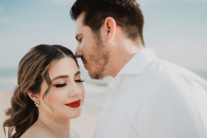 Primer plano de una pareja compartiendo un momento íntimo y tranquilo frente al mar.