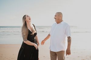 Pareja disfrutando un momento auténtico junto a una cerca antigua durante una sesión de pareja.