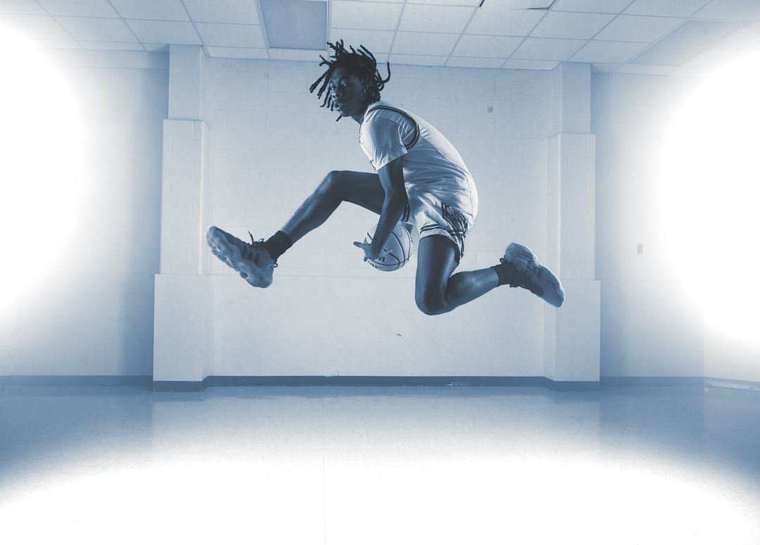 Dynamic action shot of someone jumping in mid-air against a white room backdrop.
