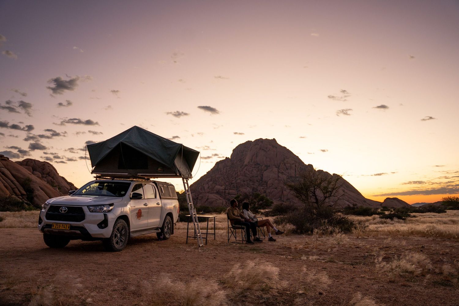 4x' avec tente de toit à spitzkoppe au coucher du soleil avec une montagne en arrière plan
