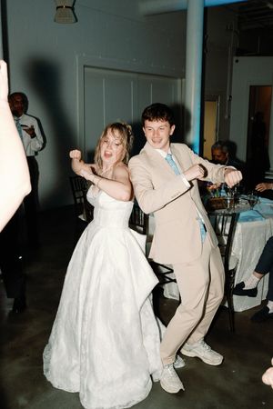 Bride and brother dancing joyfully at wedding reception, wedding dress, Dancing having fun,