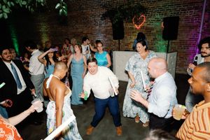 Energetic wedding reception guests dancing and celebrating together in The Elia wedding venue. Booth Creative Co. Wedding Photographer.