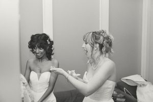 Two brides laughing and sharing a joyful moment together in black and white wedding photo. Booth Creative Co. Wilmington, NC Wedding Photos