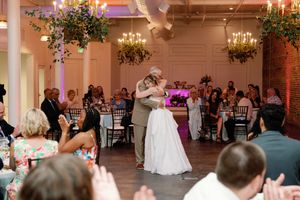 Bride and Father share dance surrounded by applauding guests in decorated venue. The Elia - downtown Wilmington, NC Wedding Venue - Weddings