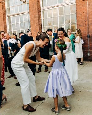 Wedding reception guests dancing energetically at brick venue.