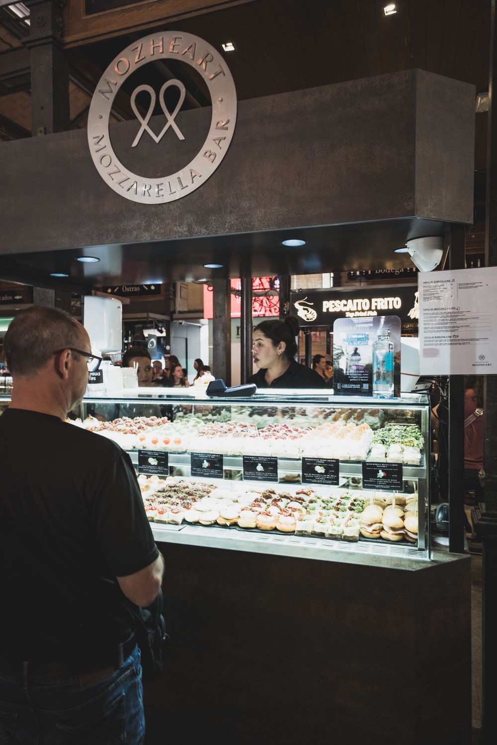 Mozheart Mozzarella Bar stall with fresh toppings display and staff serving a customer at a market.
