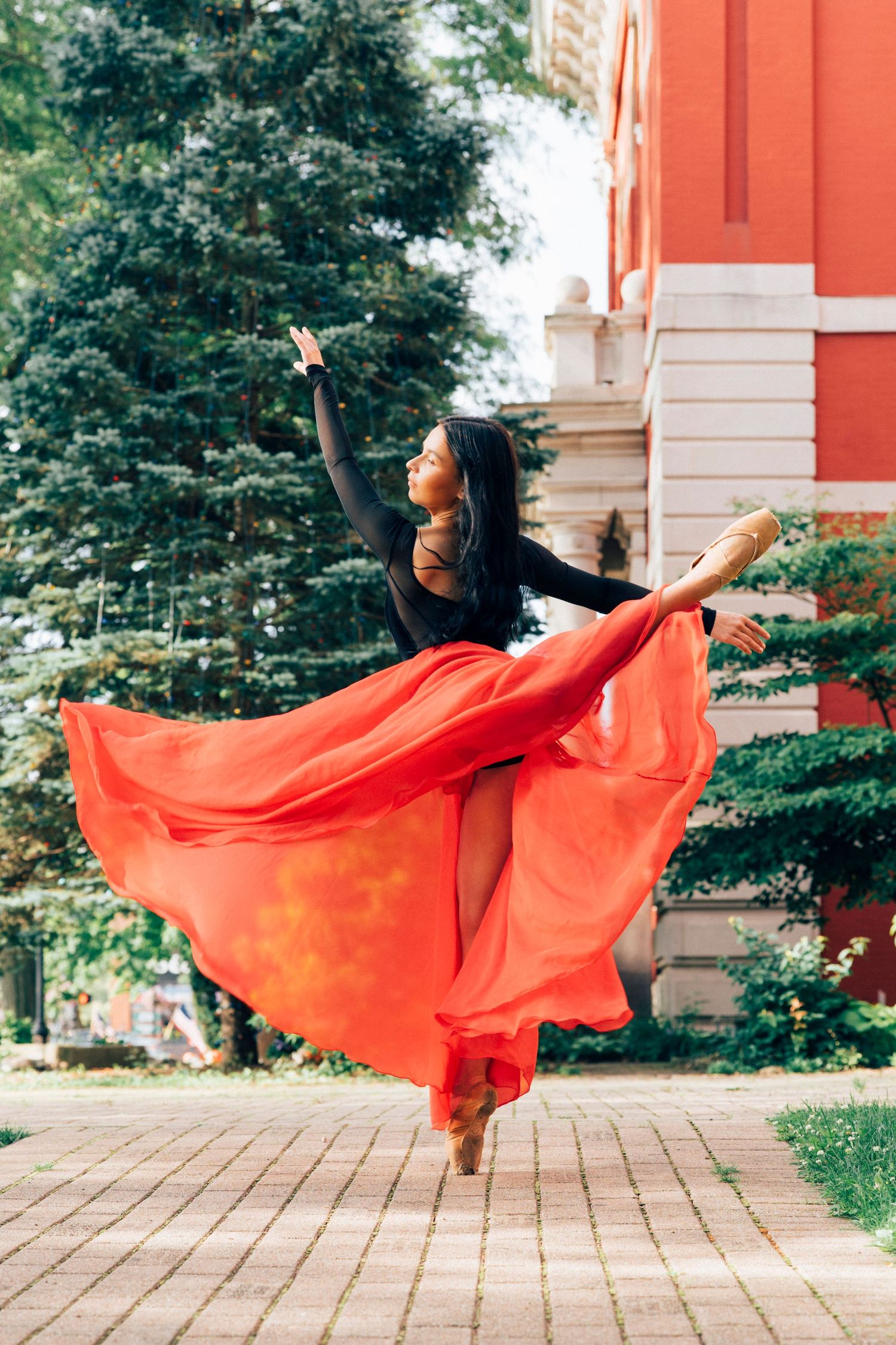 Dancer in a flowing red dress on the courthouse lawn, photographed by a professional senior portrait photographer in crown point indiana