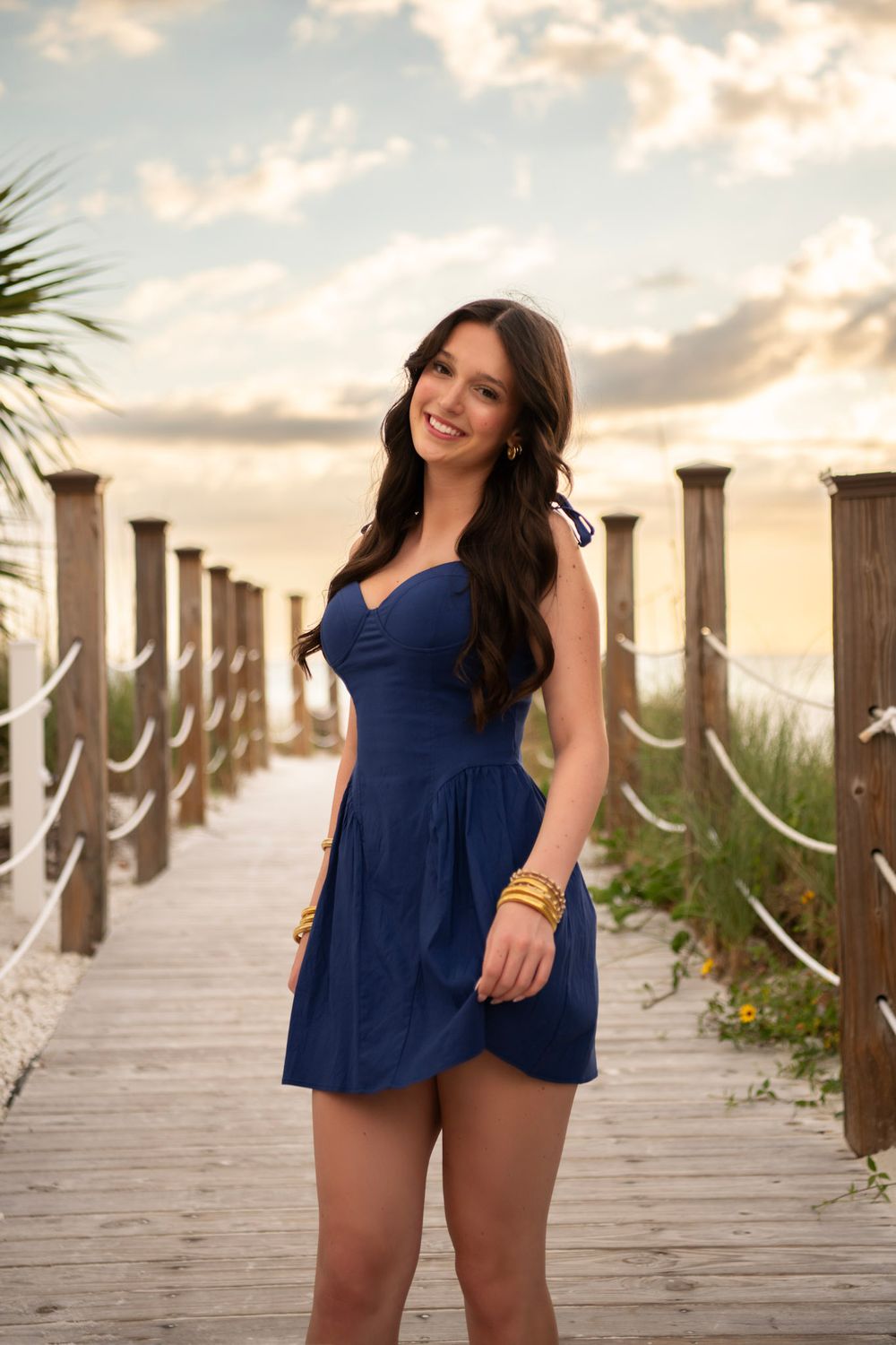 High school senior girl standing by beach dunes at Clearwater Beach during sunset senior portrait session