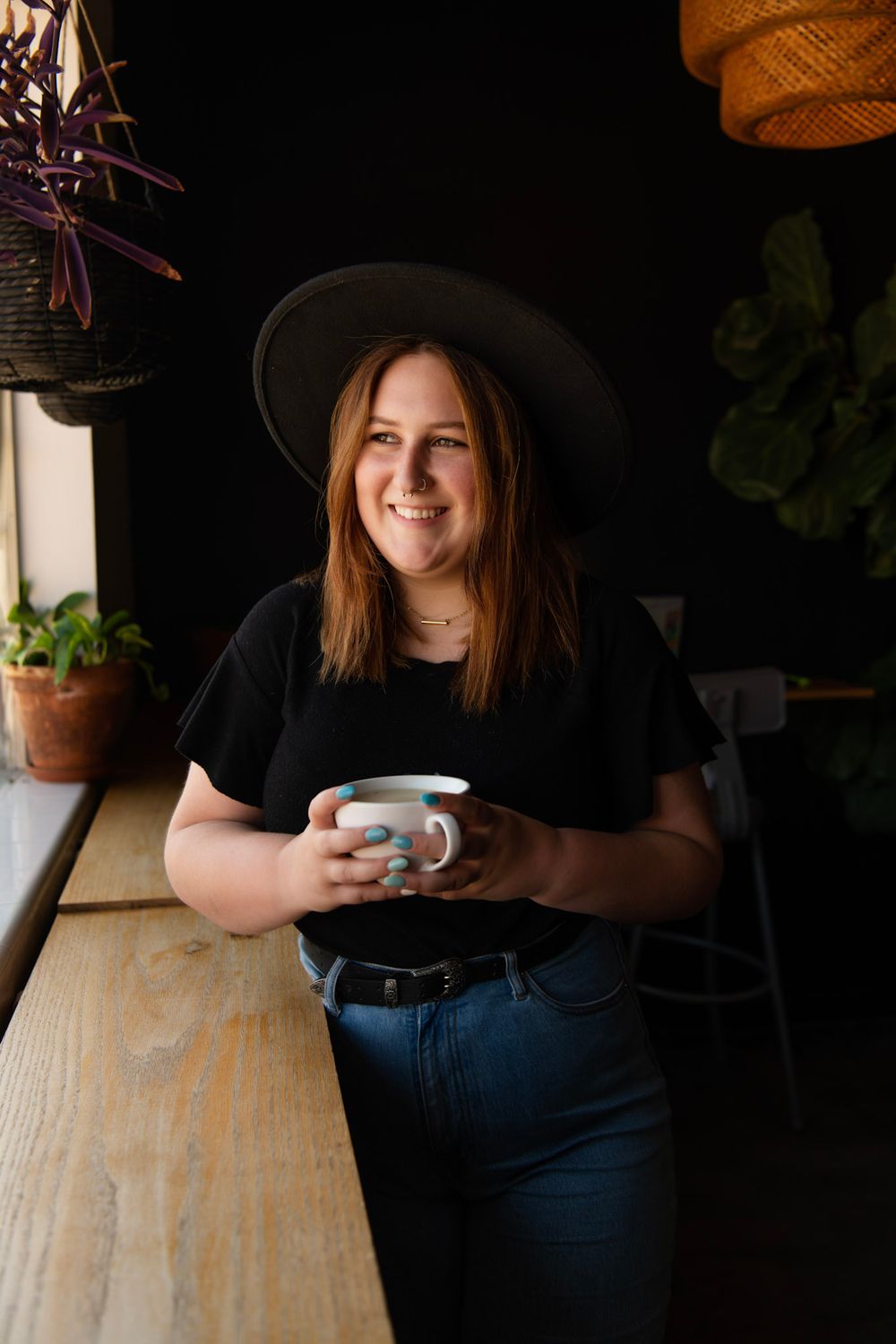 High school senior portrait at a St. Petersburg Florida coffee shop holding a coffee mug by a window.