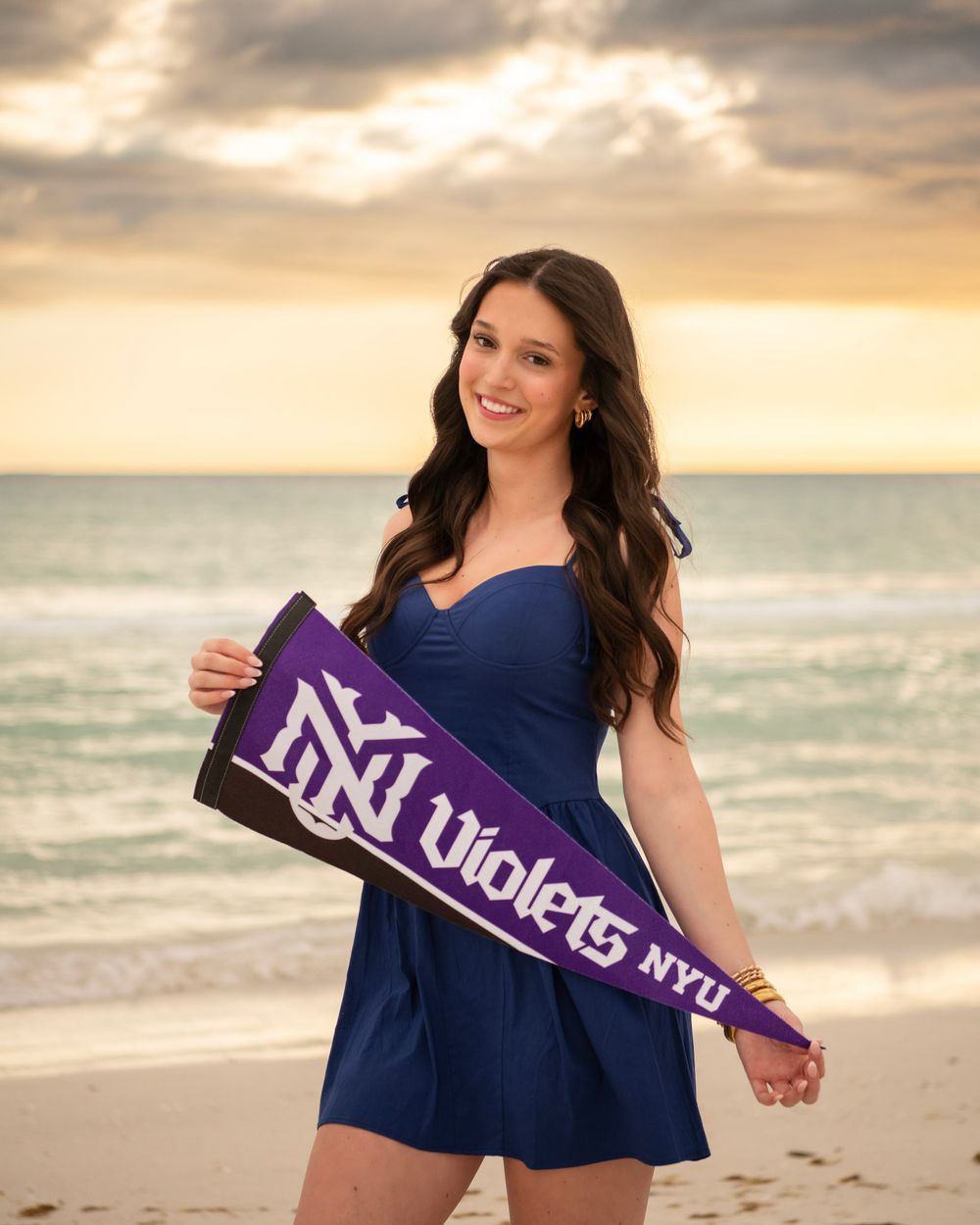Clearwater Beach senior portrait of graduate wearing blue dress and holding graduation stole.