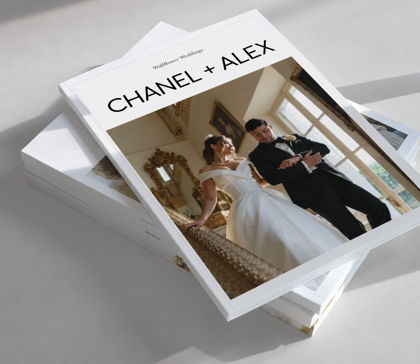 Black and white wedding photo album titled OUR DAY showing a bride in a flowing gown and veil with her groom, resting on a stack of books.