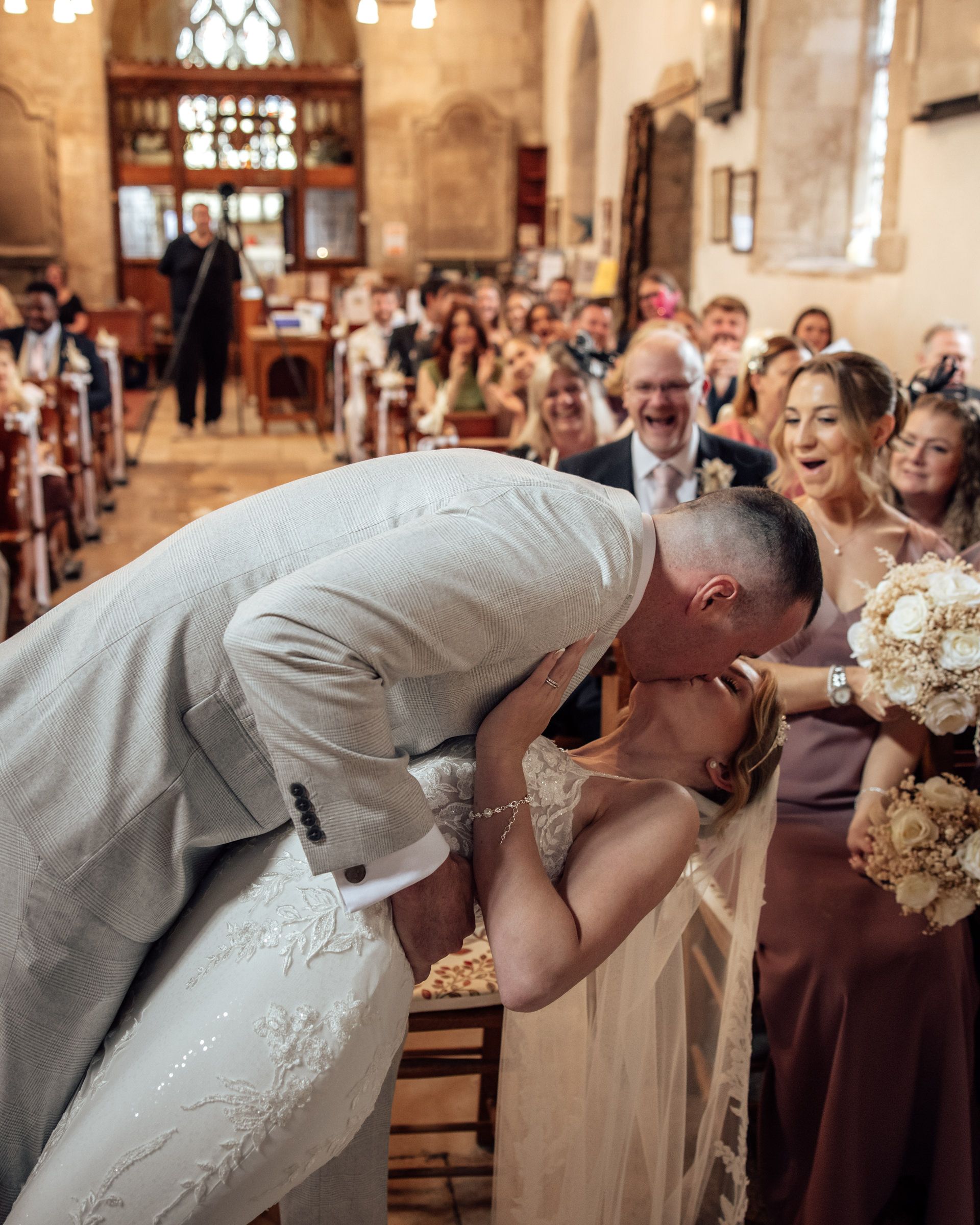 Mark dipping Shauna for a kiss during their wedding ceremony at St Michael and All Angels Church
