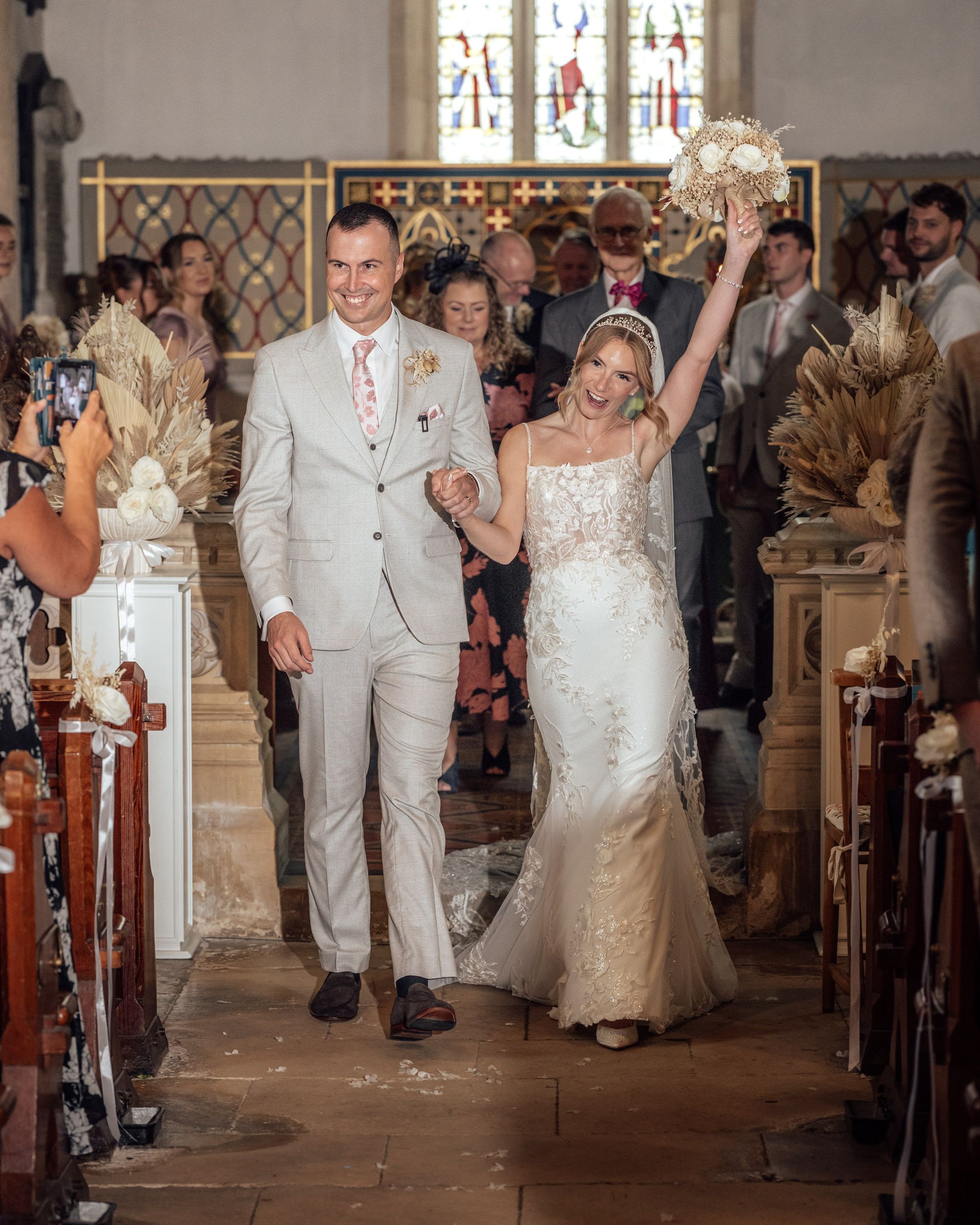 Newlyweds Shauna and Mark celebrating as they walk down the church aisle