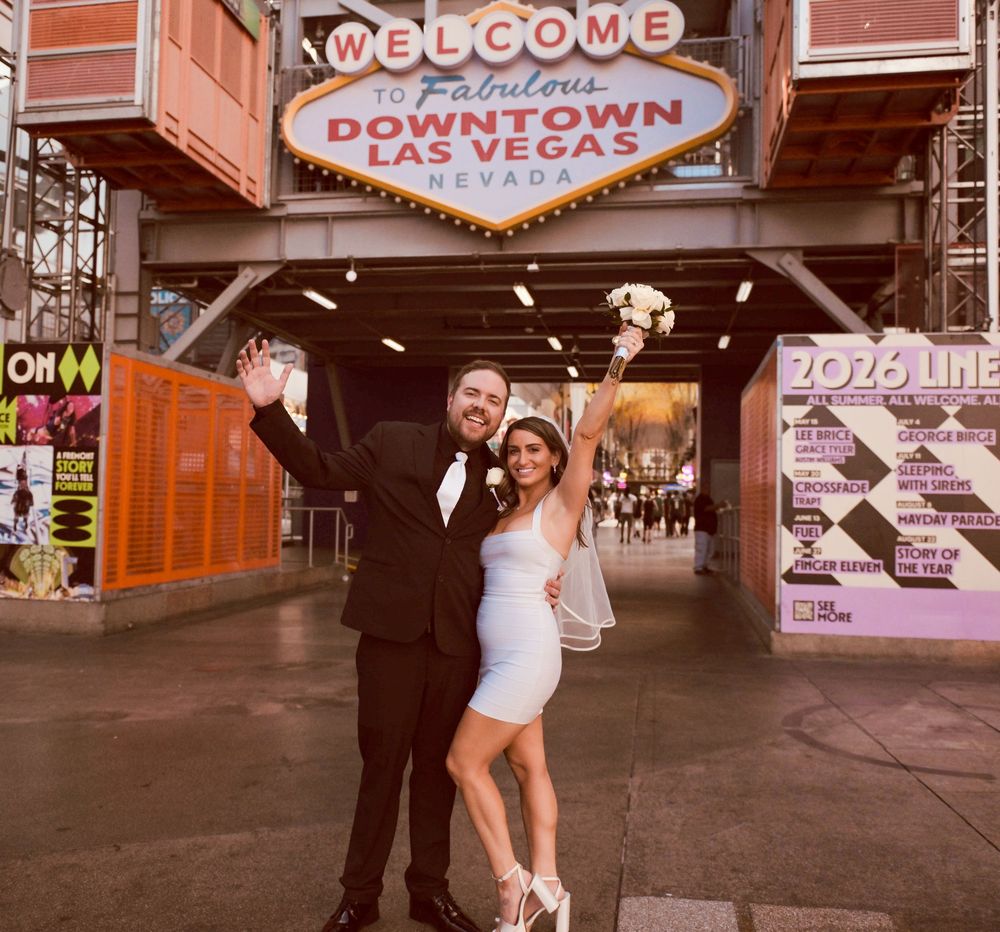 Newlyweds celebrate their Las Vegas wedding in front of the iconic Welcome to Downtown Las Vegas sign.