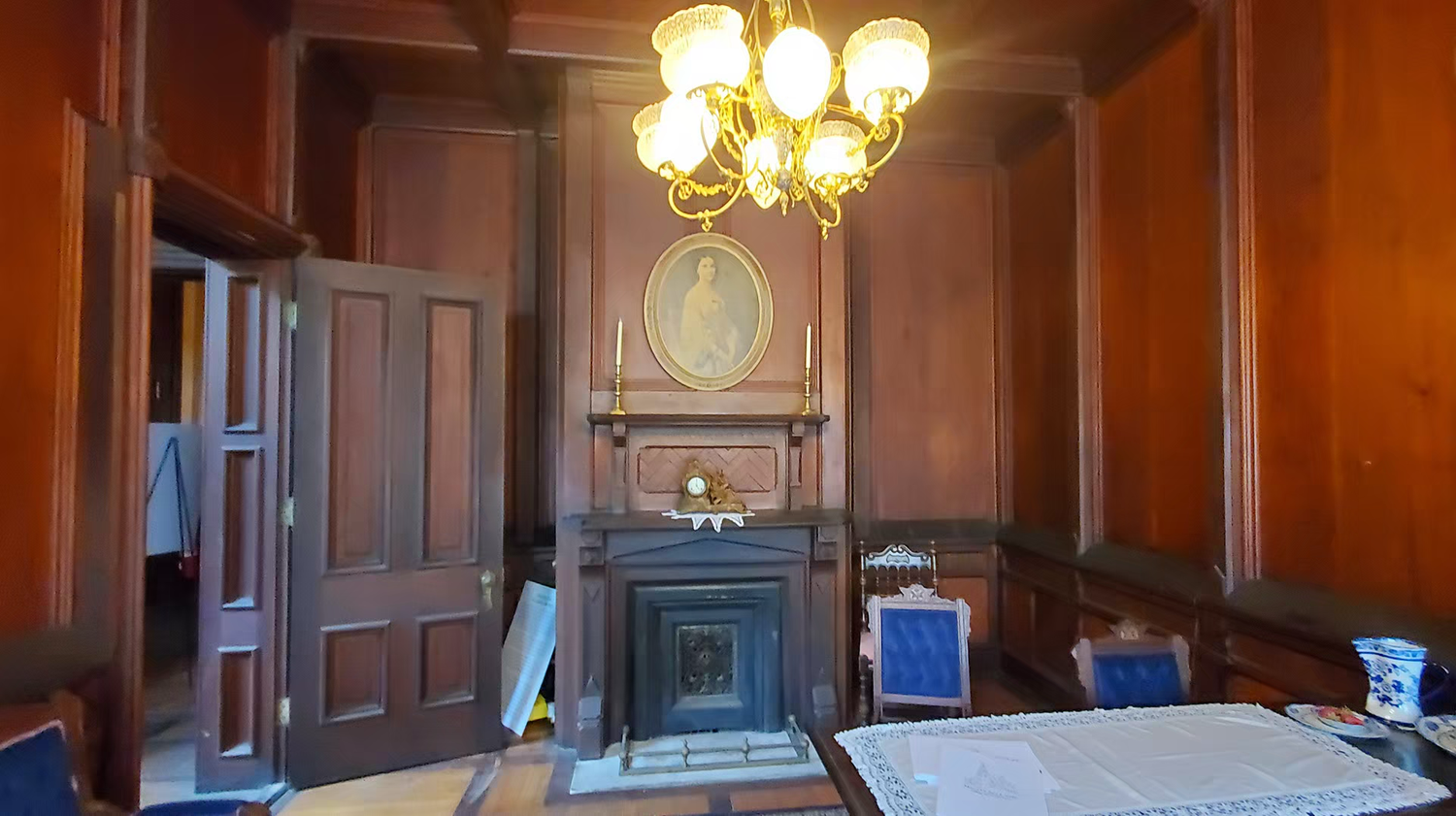 Elegant wood-paneled room with ornate chandelier at the mac-o-chee wedding venue castle