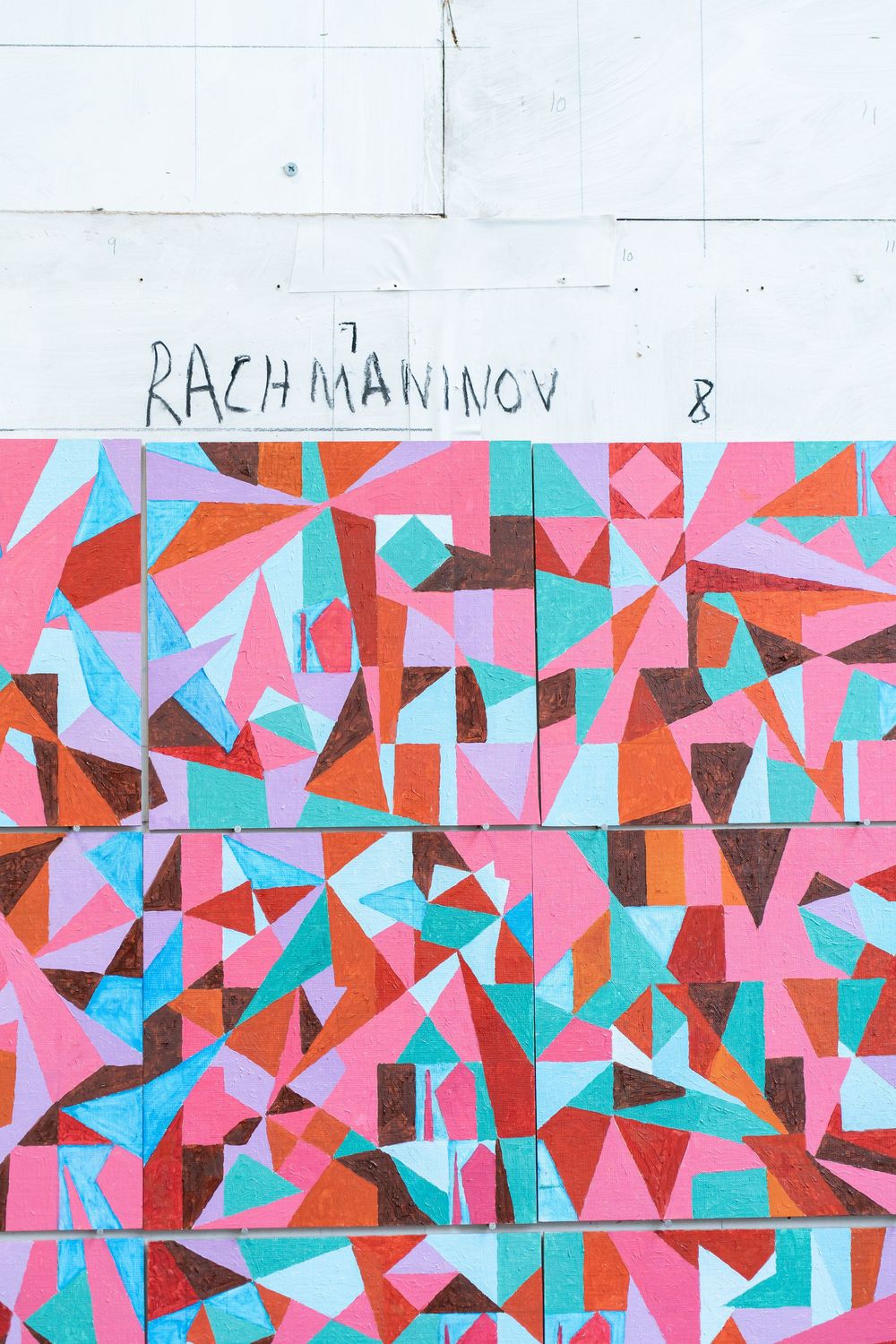 Colorful geometric abstract mural with pink, teal, and orange triangles on a wall labeled Rachmaninov 8.