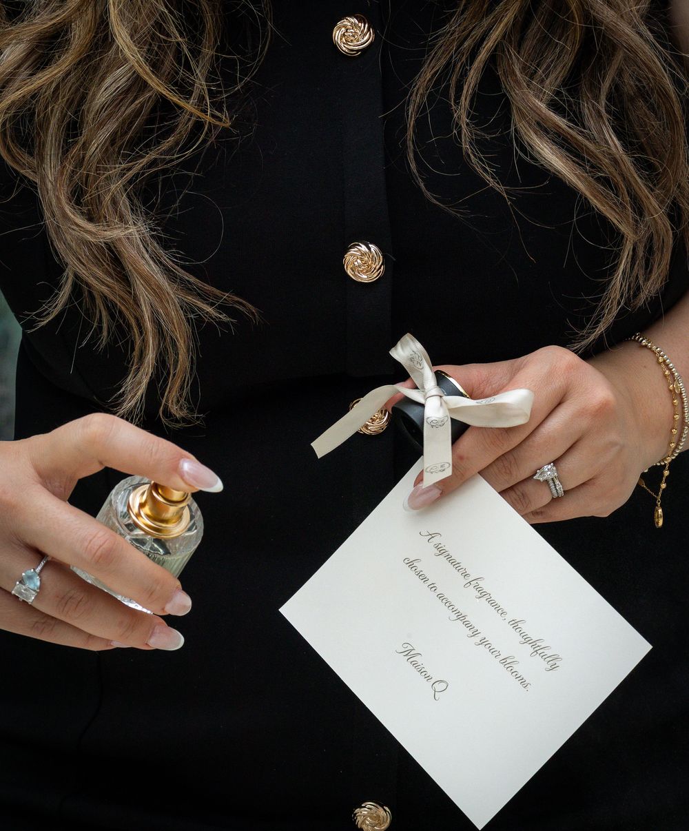 Manicured fingers spraying luxury perfume in Strongsville.