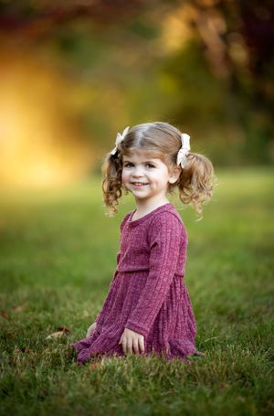 Portrait in an autumn setting with soft golden bokeh background.