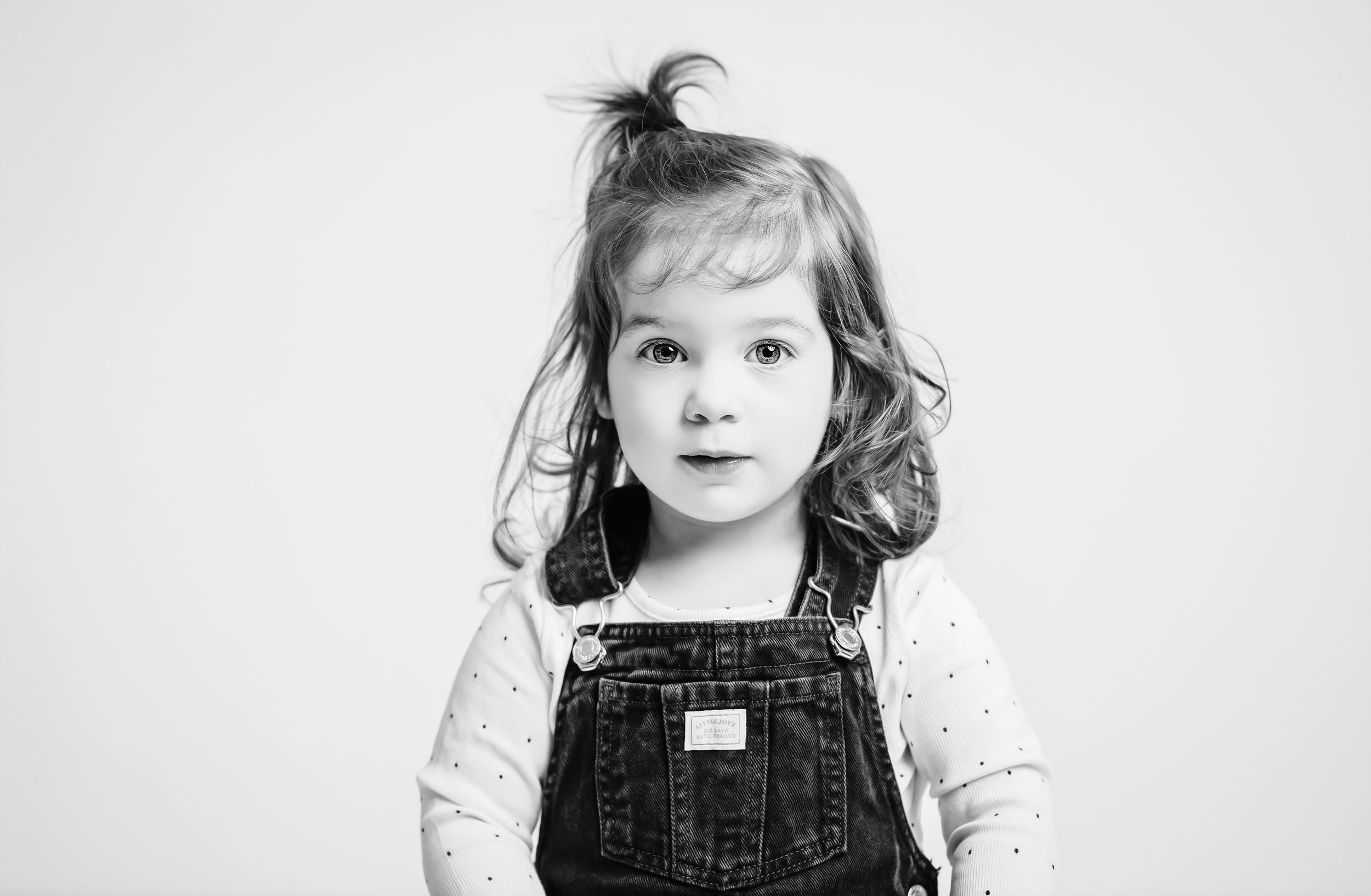 Black and white photo series showing the same child in different poses and expressions.