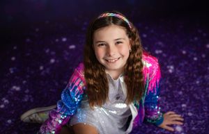 Sparkly portrait against purple galaxy backdrop.