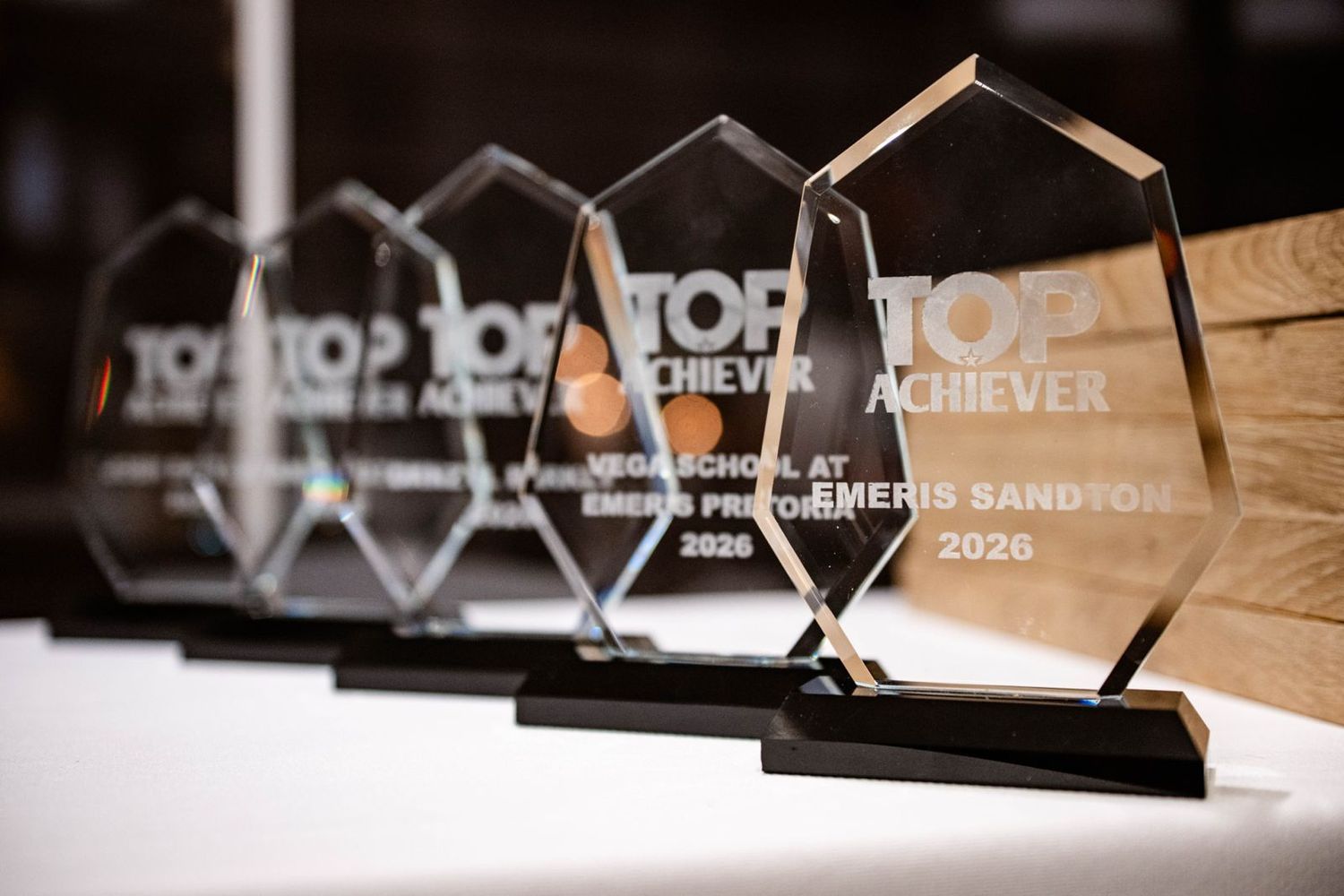 Glass achievement awards displayed during a professionally photographed corporate event.
