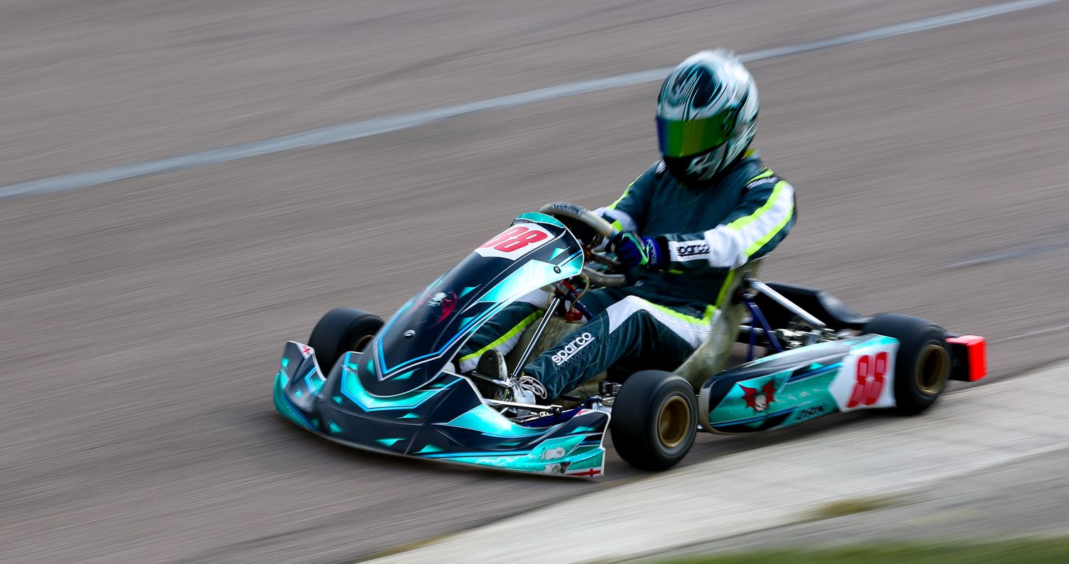 Teal and black go-kart number 88 racing on a circuit.