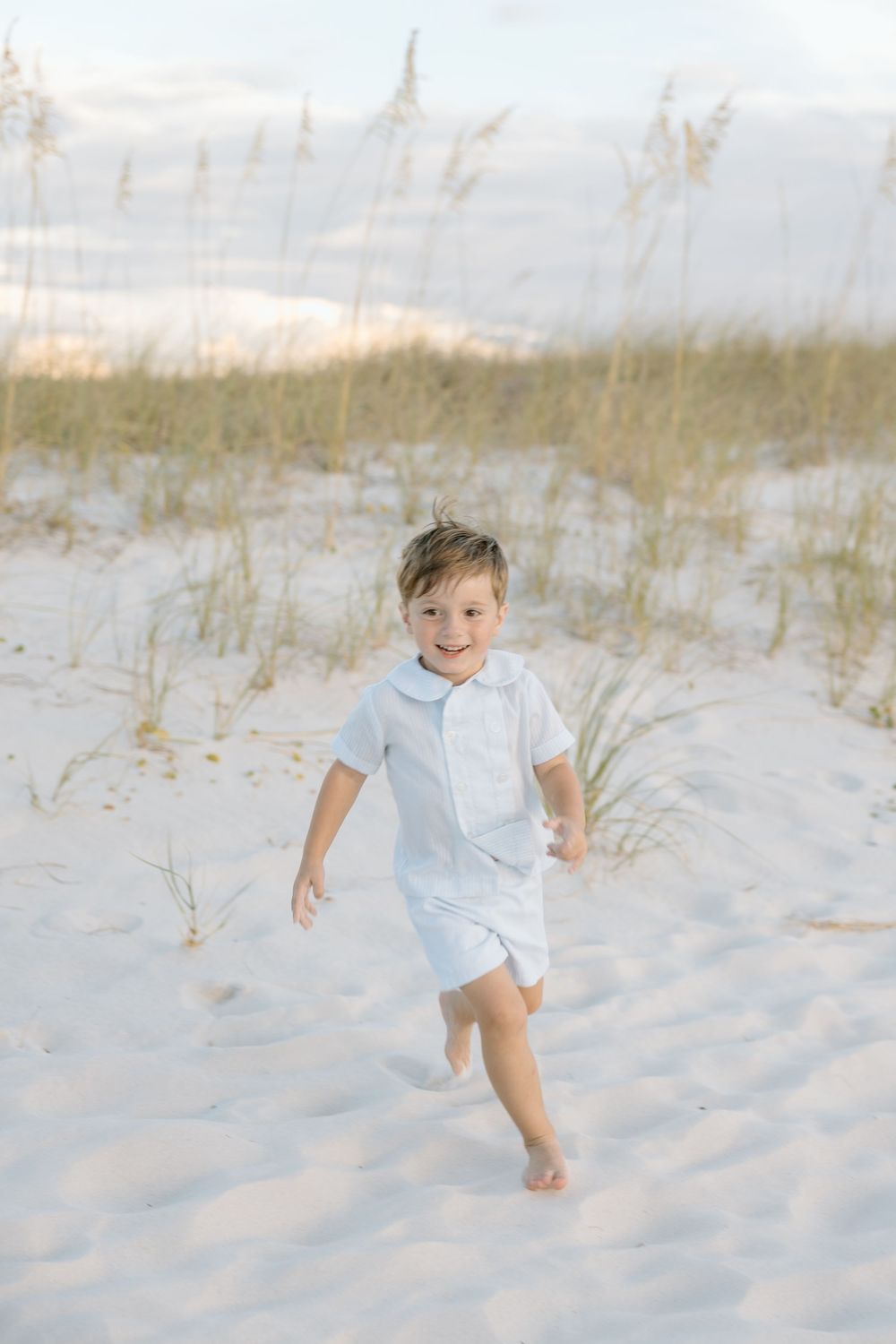 Child boy running through the sand dunes in Orange beach and gulf shores alabama.